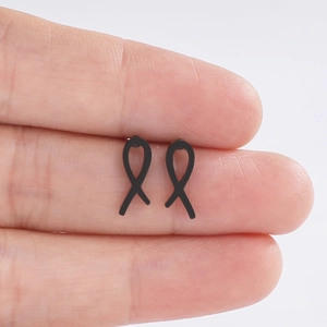 Gros plan de boucles d'oreilles nœud noir minimalistes en acier inoxydable au fini mat