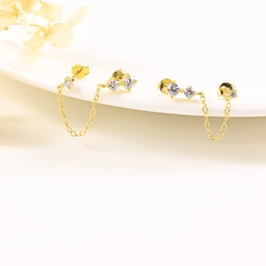 Detail of gold S925 sterling silver chain earrings with evil eye stud and crystals