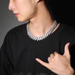 Close-up of a silver iced-out Cuban link chain on a model showing hip hop style jewelry