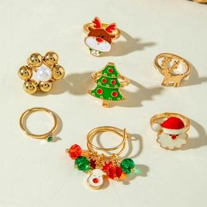 Détail du lot de bagues de Noël avec motifs élan doré, Père Noël et sapin en émail coloré