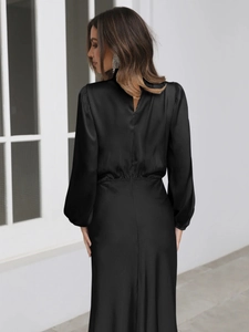 Detail of elegant black satin halter neck dress with waistline and lantern sleeve texture