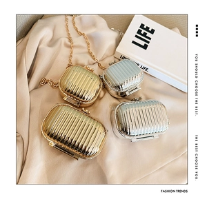 Mini metallic suitcase bags in gold and silver on silk with gold chain straps