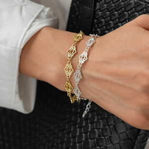 Detail of vintage hollow heart-shaped bracelet in gold and silver finish with lobster clasp