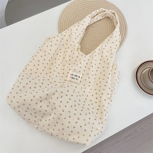 Detail of floral corduroy tote bag showing soft fabric texture and stitched brand label