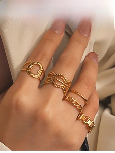 Macro shot of gold plated crisscross and geometric ring set on fabric background