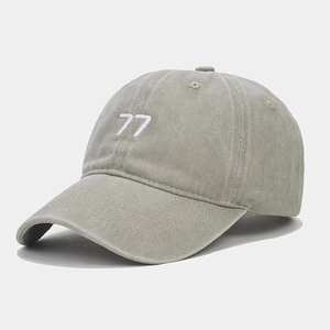 Détail de la broderie 77 blanche sur une casquette en coton gris délavé vintage
