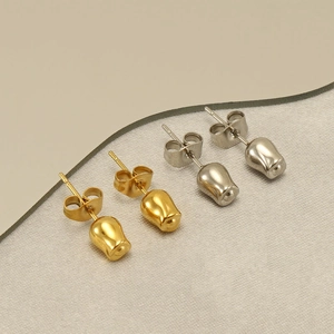 Minimalist tulip bud stud earrings in polished gold and silver finishes on fabric