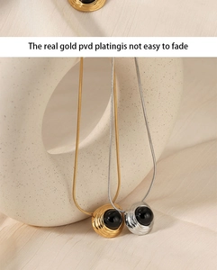 Detail of gold and silver PVD plated 316L stainless steel necklaces with black agate pendant