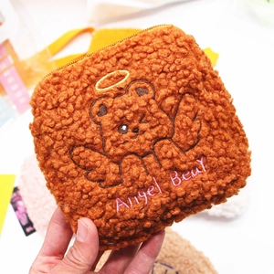 Close-up of brown plush sanitary pad pouch with cute angel bear embroidery and zipper