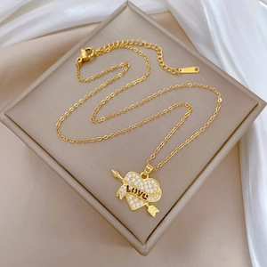 Close-up of gold heart pendant with crystal pavé, arrow design and LOVE engraving
