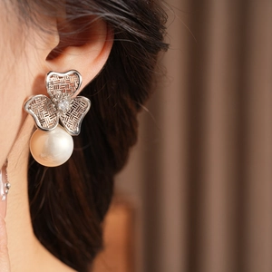 Detail of silver vintage floral earring with hollow mesh petals and a large pearl drop