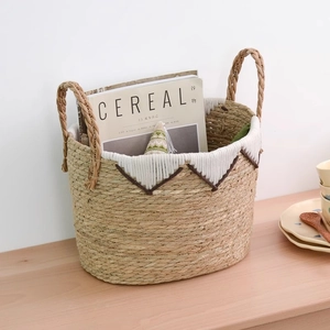 Handwoven straw storage basket with white tassels and handles for home organization