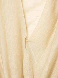 Macro detail of V-neckline with small metal hook closure on beige slim fit top