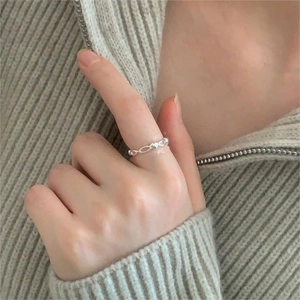 Detail of silver heart shaped pattern ring worn by a model on finger for daily style