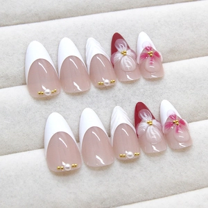 Elegant pearl white almond press-on nails with 3D floral accents and French tips