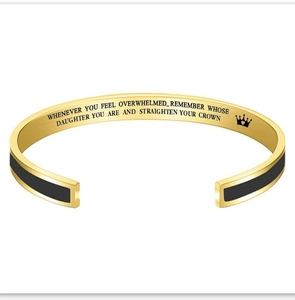 Detail of inspirational quote and crown engraving inside the gold cuff bracelet