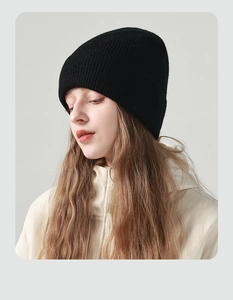 Nahaufnahme der schwarzen Strickmütze mit weicher Rippstruktur und engem Sitz am Modell