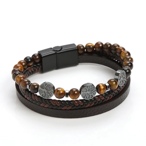 Dettaglio dell'albero della vita su bracciale in pelle multistrato con pietre occhio di tigre