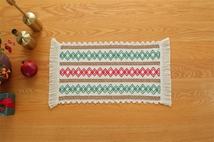 Macro view of woven Christmas table runner with red and green patterns and tassels