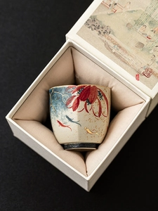 Detailed macro view of a ceramic teacup with koi fish art in an elegant gift box