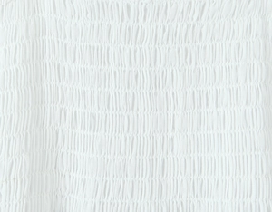 Gros plan détaillé du tissu smocking blanc avec broderies plissées délicates et précises