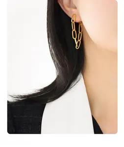 Close-up of elegant double chain tassel earrings in gold plating worn by a model