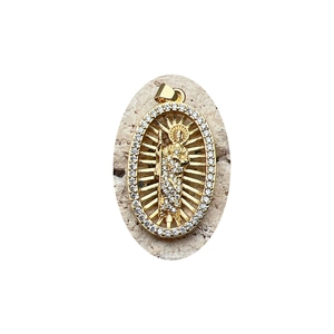 Oval gold Jesus pendant with white zircon halo on light textured stone background