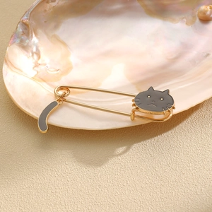 Detailed view of cat brooch with black enamel tail pendant inside a pearly shell