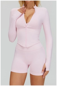 Détail de l'ensemble de yoga sans couture rose avec haut zippé et short de sport gainant