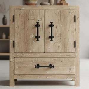 Meuble vintage en bois clair avec poignées en fonte dans un décor maison minimaliste