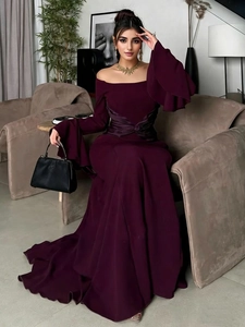 Detail of elegant off-shoulder velvet evening dress with dramatic ruffled flare sleeves