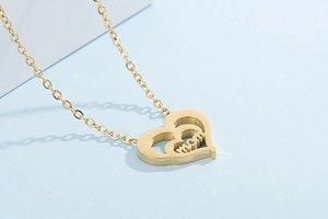 Close-up of gold double-layer heart pendant with MOM engraving for Mother's Day gift