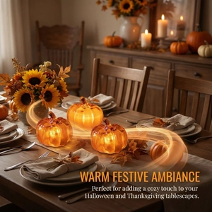 Three glowing LED glass pumpkins set with warm lights for Halloween table decor