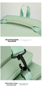 Detail of mint green travel bag featuring reinforced handles and detachable shoulder strap hooks