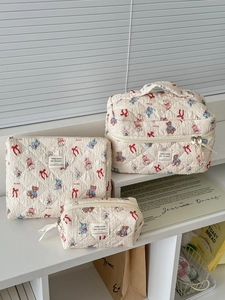 Detailed set of three quilted storage bags with animal prints and woven labels