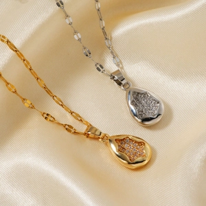Collier pendentif goutte d'eau en or et argent avec zircons sur fond de soie