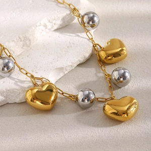 Vue détaillée du pendentif cœur plaqué or 18K et des perles argentées sur la chaîne