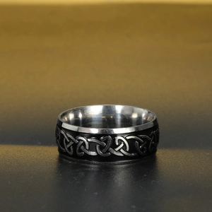 Macro detail of Nordic Celtic knot engraving on silver and black stainless steel ring