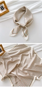 Detail of silk-like square scarf featuring horse head geometric patterns and soft satin luster