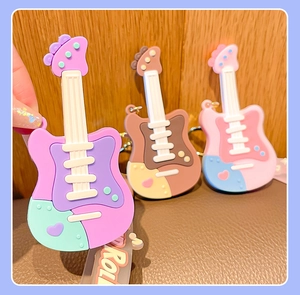 Close-up of colorful silicone guitar keychains in macaron colors on a wood background