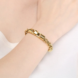 Polished gold stainless steel braided chain bracelet with large folding clasp on wrist