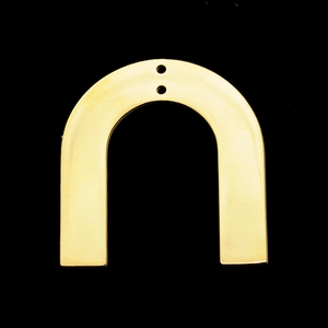 Macro detail of golden U-shaped stainless steel jewelry pendant with two small holes