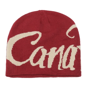 Detail of red knit beanie featuring white Canada jacquard lettering and textured fabric