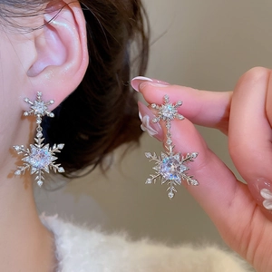 Detailansicht silberner Schneeflocken-Ohrringe mit Zirkonia und Perlen an einem Modell