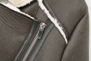Macro detail of dark brown faux leather jacket with cream fleece lining and silver zipper