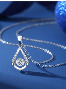 Macro shot of silver teardrop pendant with moving center cubic zirconia and side stones