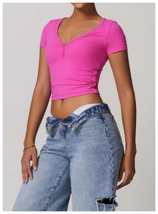Detail of rose pink slim fit crop top featuring silver button neckline detail