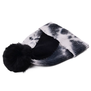 Detail of the tie-dye knit beanie with a large black faux fur pom-pom on plain white background
