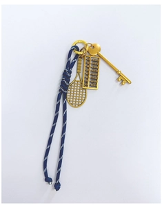 Detail view of woven blue rope keychain with gold tennis racket, abacus, and key pendants