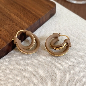 Detailed close-up of 18k gold-plated double-layer hoop earrings with mocha brown texture